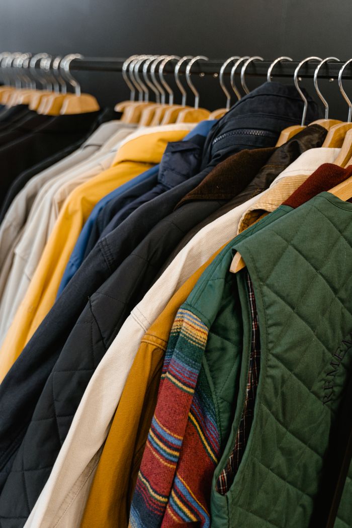 A stylish assortment of jackets and vests neatly hanging in a boutique store display.